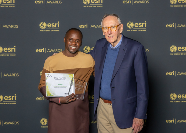 Ngugi Kimani receives the award on behalf of RCMRD from Esri President Jack Dangermond Image